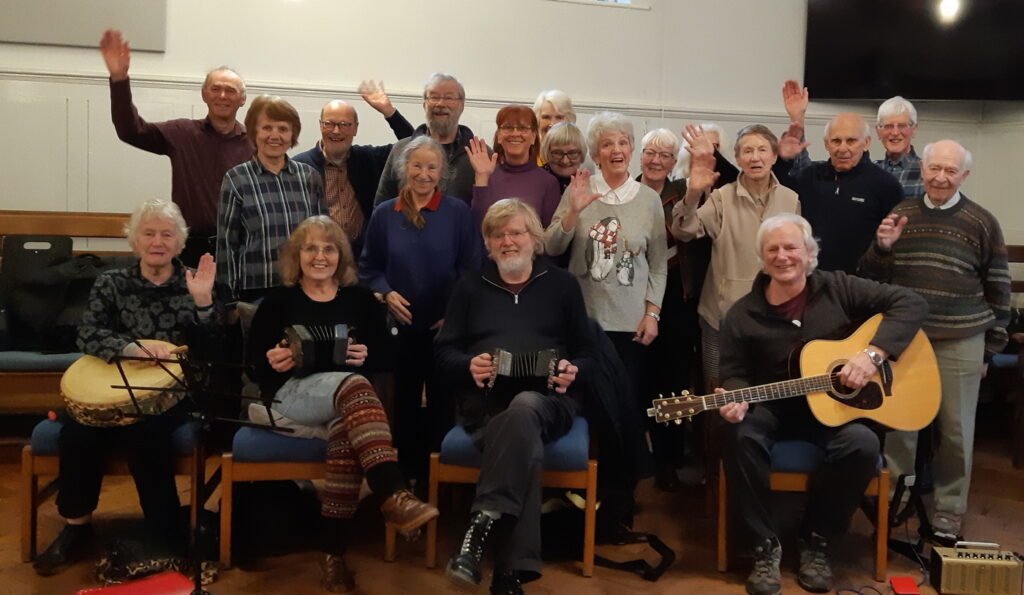 The Folk Dancing group with the five members of the band, posed for the Christmas photo.