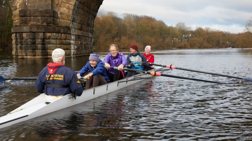 Four people and a cox rowing under the Lune Aqueduct.