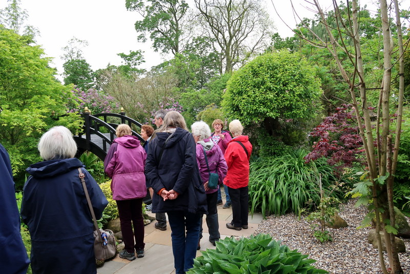The members of the Gardening Group with Linda, the owner of the garden showing the Japanese bridge in the background.