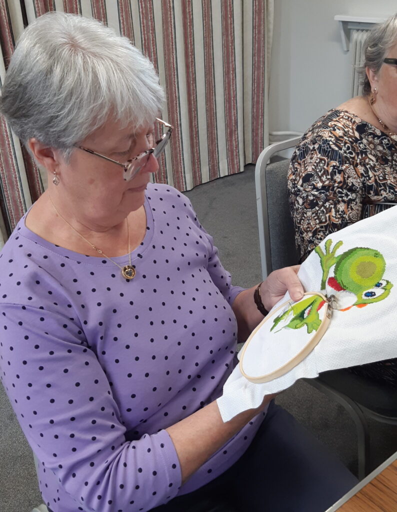 A lady concentrating on her embroidery.