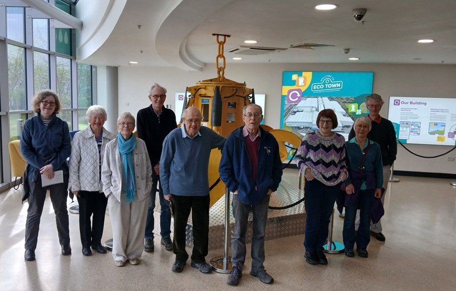 A group of ladies and gentlemen in front of a display.