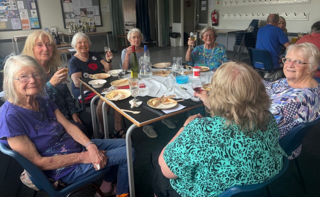 A group of ladies with food and wine.